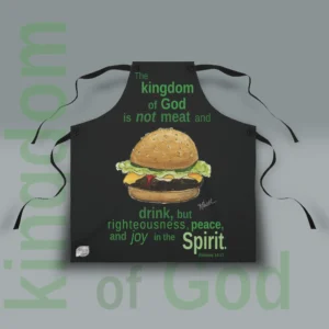 New Kingdom of God Apron: Joy in the Spirit being shown flat to display the fit and finish of this exceptional quality and stylish product. Perfect for your next grill out or daily use around the kitchen. with the Text Kingdom of God shown in the background