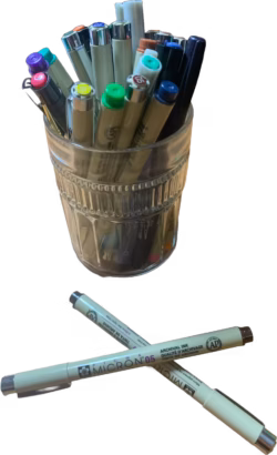 assorted markers and paint pens in a jar